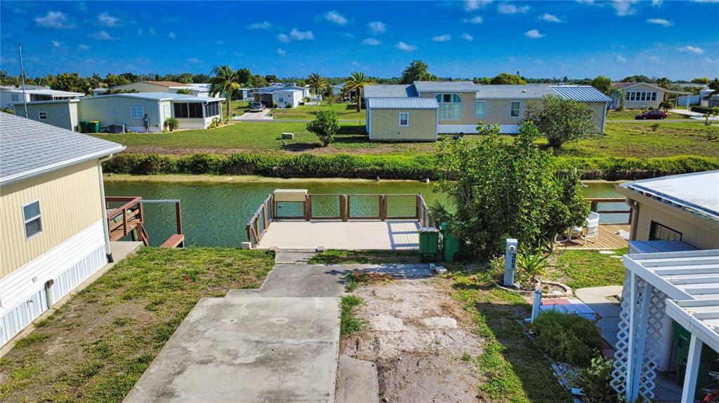 An elevated view of a mobile home backyard featuring a wooden deck overlooking a canal — 1475 FLAMINGO DRIVE UNIT 389, ENGLEWOOD, FL