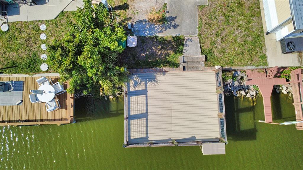 An aerial view shows a wooden deck extending over a lake next to a patio — 1475 FLAMINGO DRIVE UNIT 389, ENGLEWOOD, FL