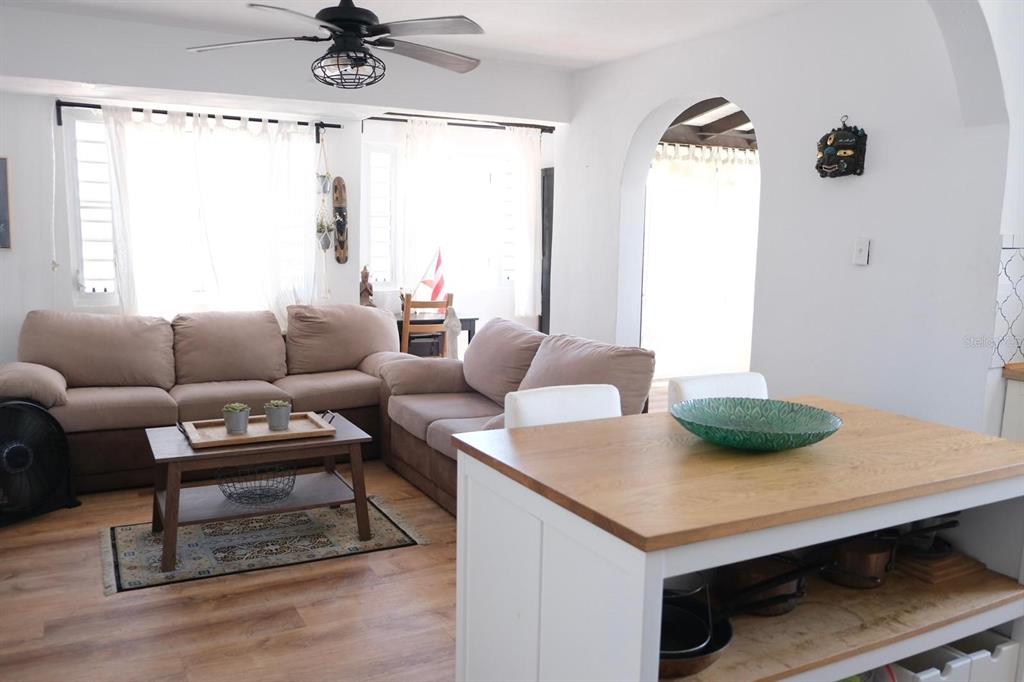 A living room with a sectional sofa, coffee table, and a kitchen island in the foreground — 200 SOL ST. UNIT PH-D1, OLD SAN JUAN, PR