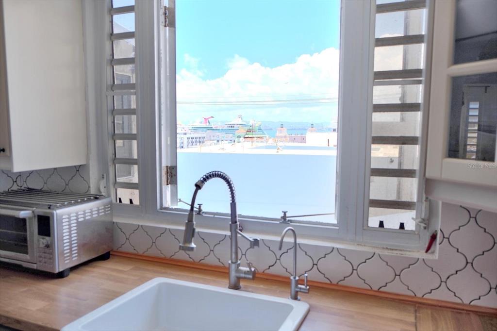 A kitchen sink with a view of a cruise ship through an open window — 200 SOL ST. UNIT PH-D1, OLD SAN JUAN, PR
