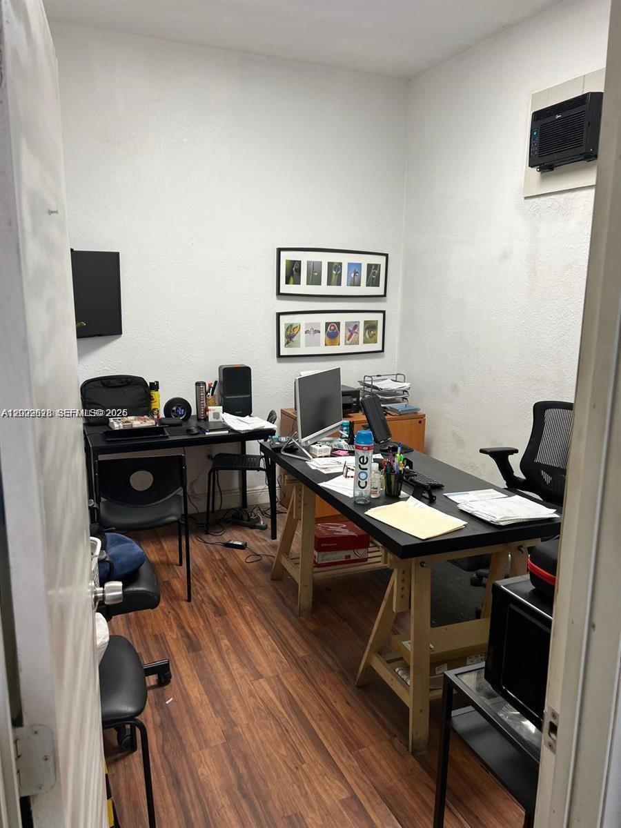 A small office features two desks, wood-look flooring, and wall-mounted artwork — 1950 Hayes St, Hollywood FL 33020, HOLLYWOOD, FL