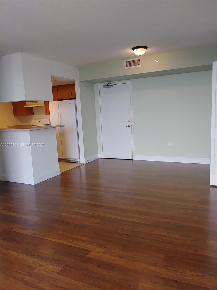 An interior view shows a living area with hardwood floors, a kitchen, and an entryway — 816 NW 11th St # 1002, Miami FL 33136, MIAMI, FL