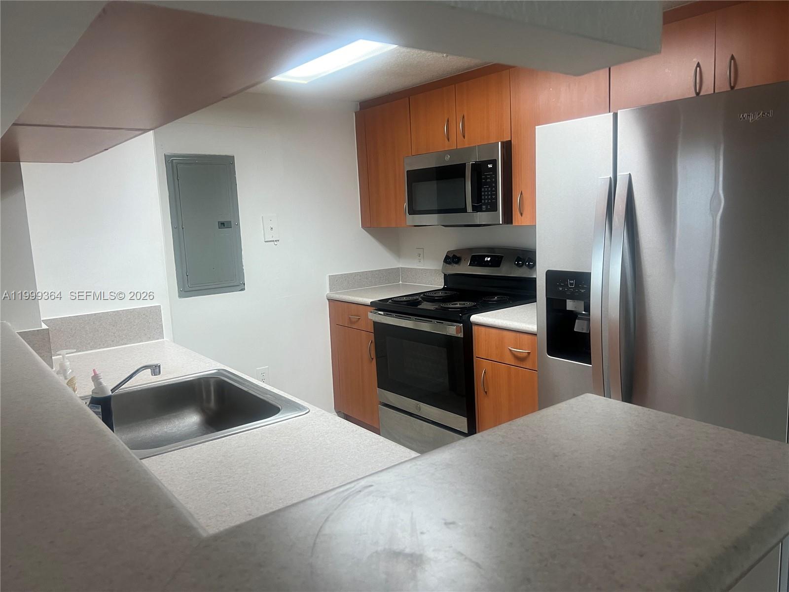 A kitchen features wood cabinets, stainless steel appliances, and light-colored countertops — 816 NW 11th St # 1002, Miami FL 33136, MIAMI, FL