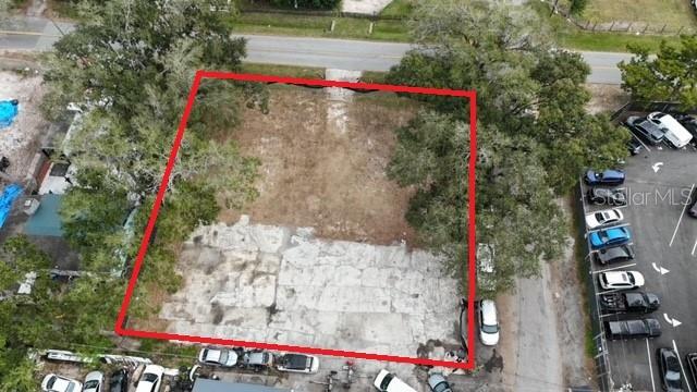 An aerial view shows a vacant, rectangular lot outlined in red next to a parking area — 9330 1ST AVENUE, ORLANDO, FL