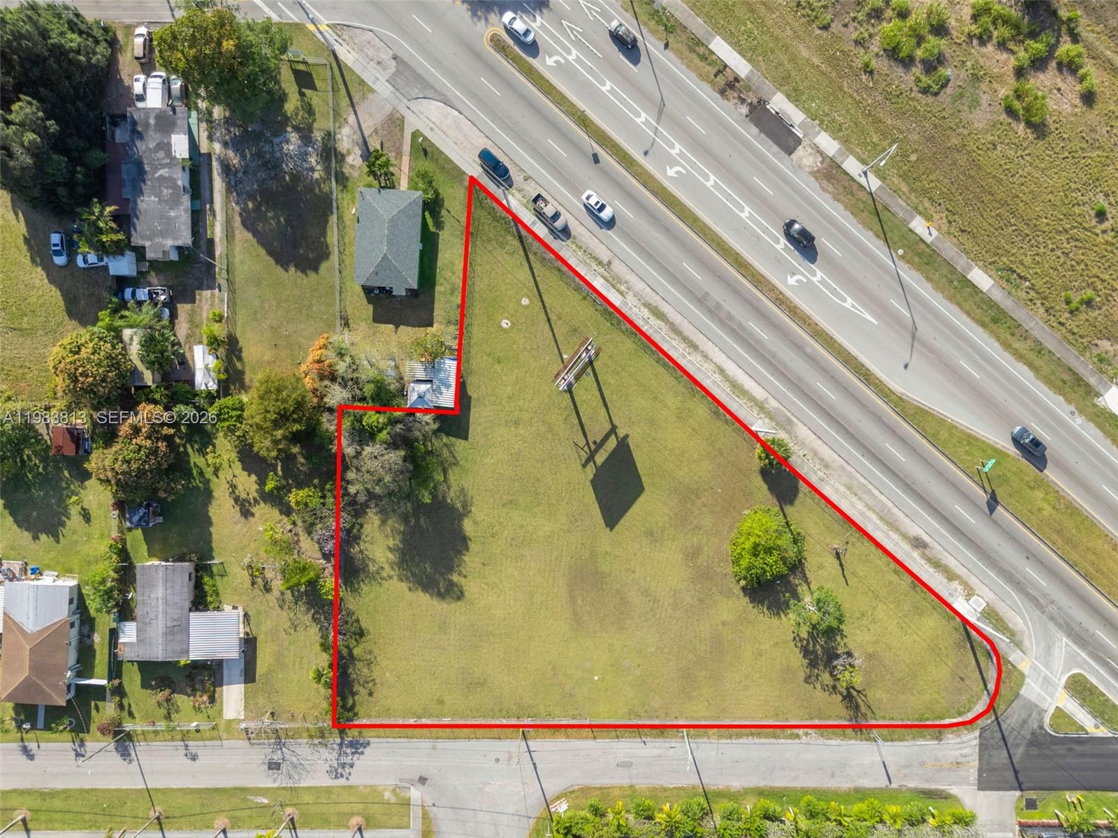 This aerial view shows a vacant, triangular-shaped lot outlined in red next to a road — 21710 SW 118th Ave, Miami FL 33170, MIAMI, FL