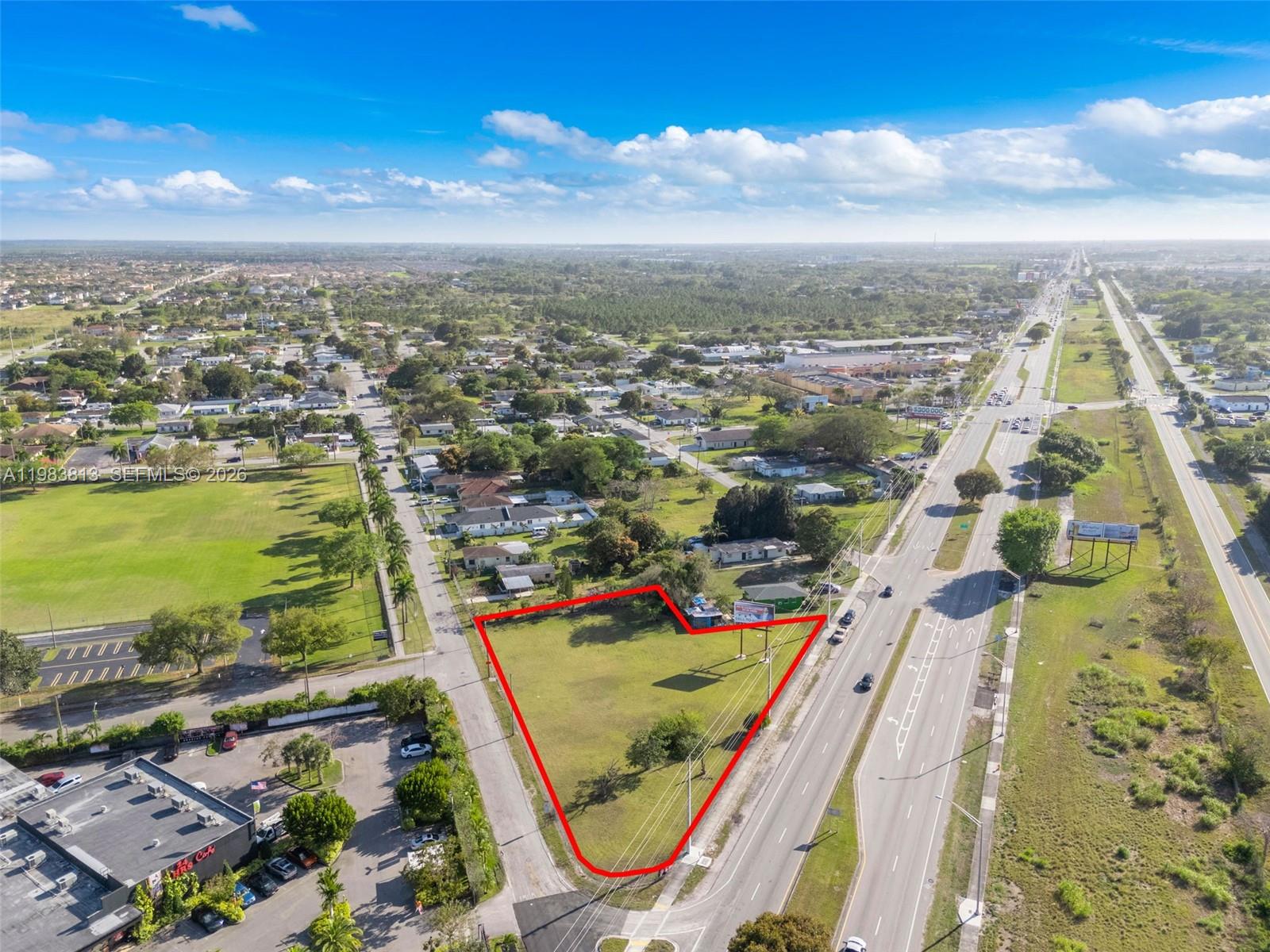 An aerial view shows a vacant, triangular-shaped lot outlined in red next to a highway — 21710 SW 118th Ave, Miami FL 33170, MIAMI, FL