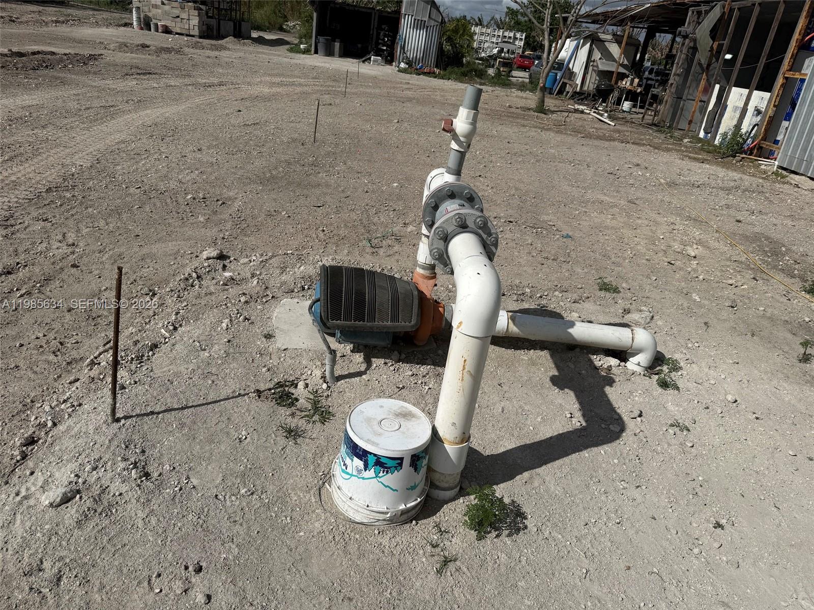 An outdoor water pump system sits on a concrete pad in a dirt lot — 16455 SW 207, Homestead FL 33187, HOMESTEAD, FL