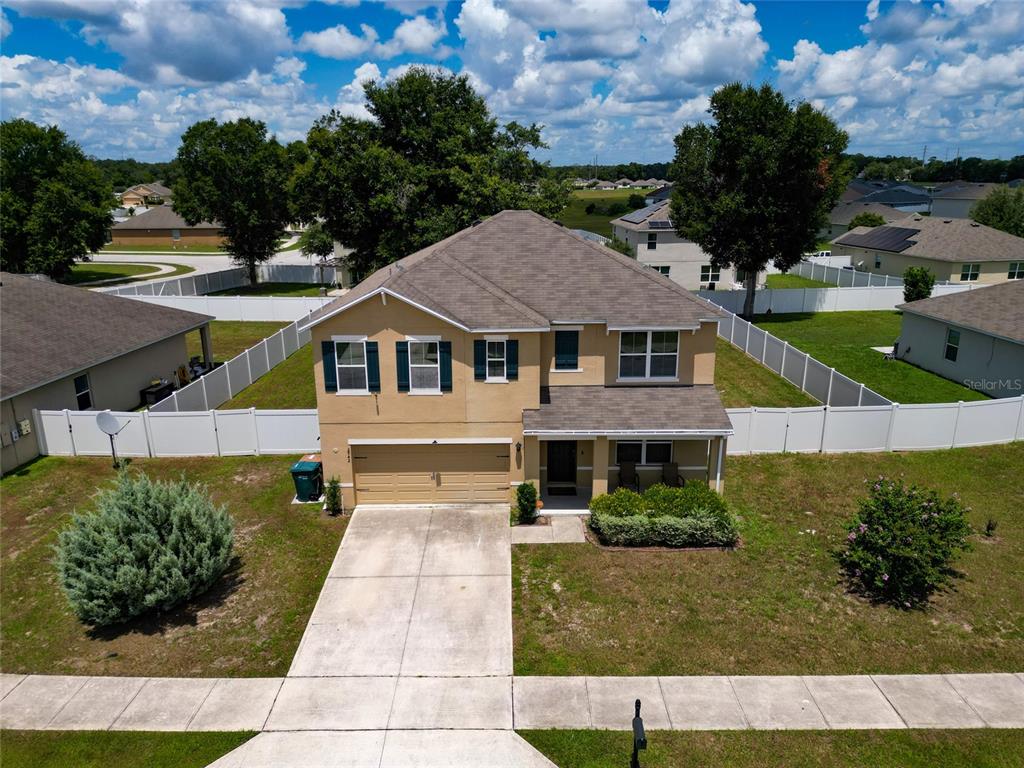 An aerial view of a two-story suburban house with a tan exterior and concrete driveway — 2942 NE 46TH AVENUE, OCALA, FL