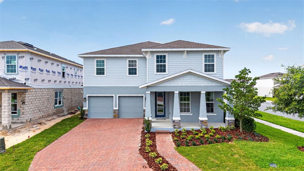 A two-story house with a brick driveway, two-car garage, and a covered front porch — 3894 CAPITAL REEF WAY, APOPKA, FL