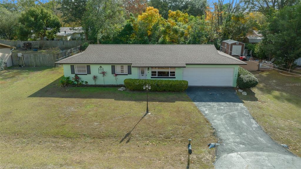 A single-story house with a light green exterior, a dark roof, and an attached garage — 2004 NE 52ND STREET, OCALA, FL