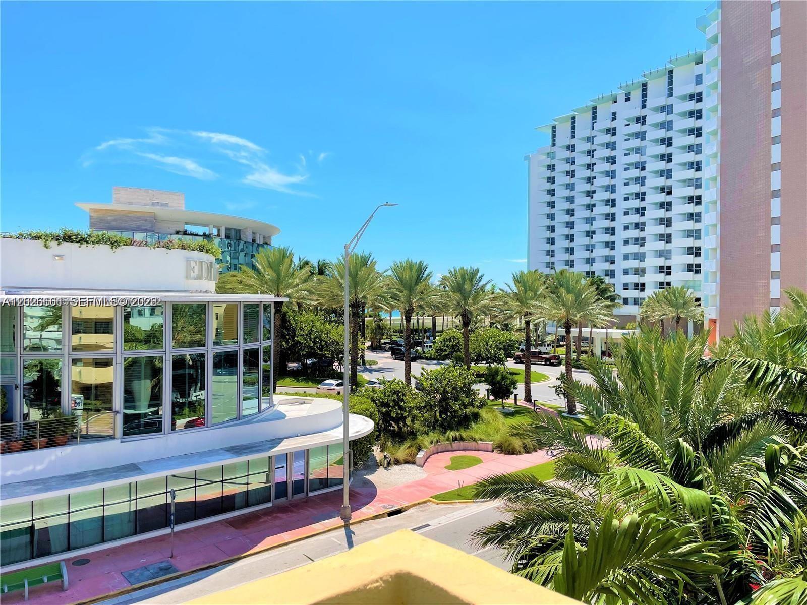 An elevated view shows a modern glass building, palm trees, and a tall residential tower — 2924 Collins Ave # 301, Miami Beach FL 33140, MIAMI BEACH, FL