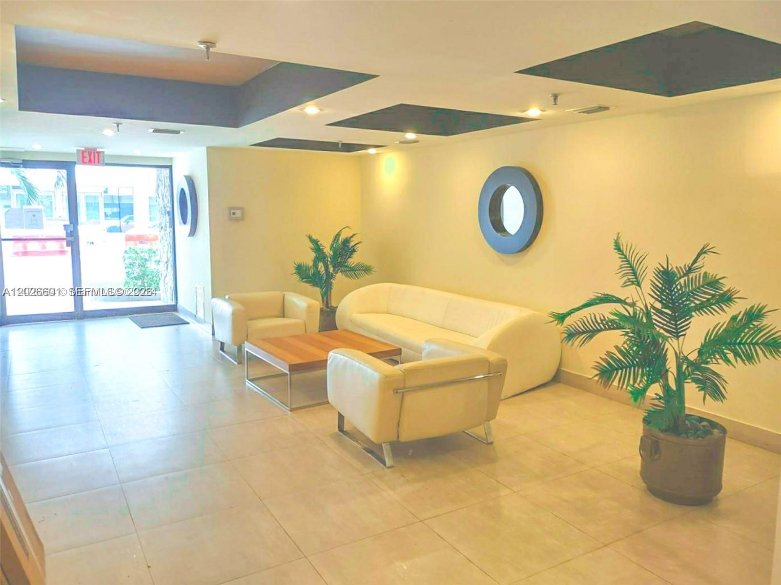 A lobby features a white sofa, two armchairs, a coffee table, and two potted plants — 2924 Collins Ave # 301, Miami Beach FL 33140, MIAMI BEACH, FL