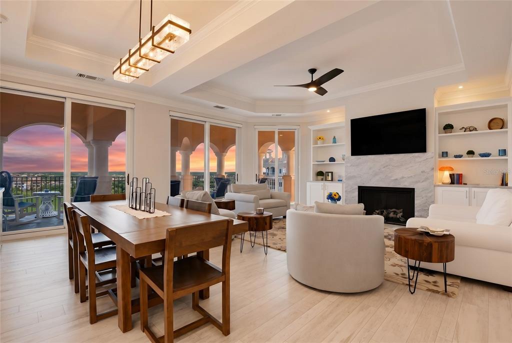 An open-concept living and dining area features a fireplace, modern furniture, and a balcony view — 200 OCEAN CREST DRIVE UNIT 642, PALM COAST, FL