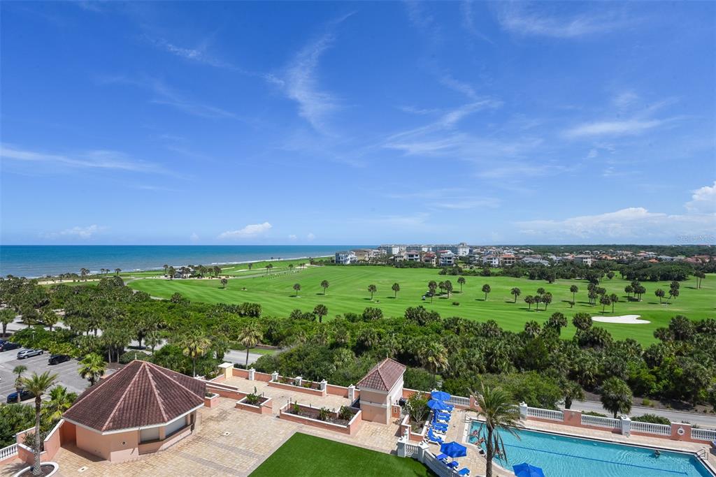 An elevated outdoor view shows a swimming pool, a golf course, and the ocean beyond — 200 OCEAN CREST DRIVE UNIT 642, PALM COAST, FL