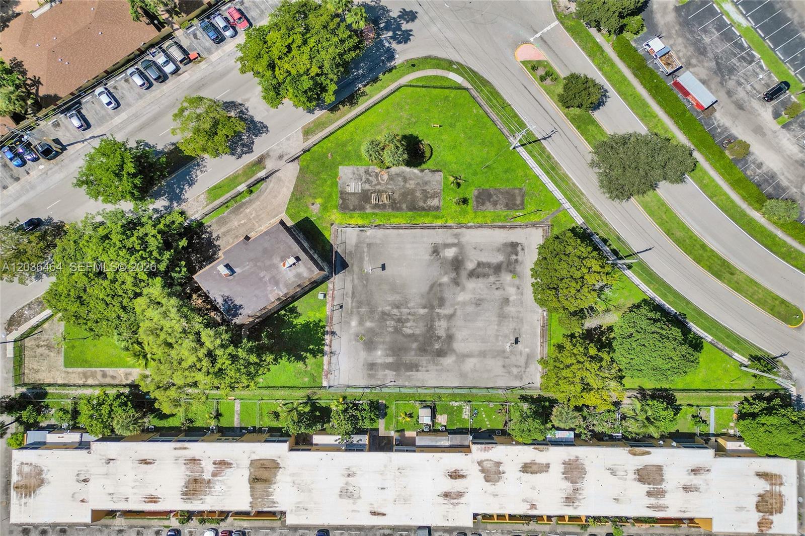 An aerial view shows a fenced basketball court, a small building, and surrounding green space — 2600 NW 60th Ter, Sunrise FL 33313, SUNRISE, FL