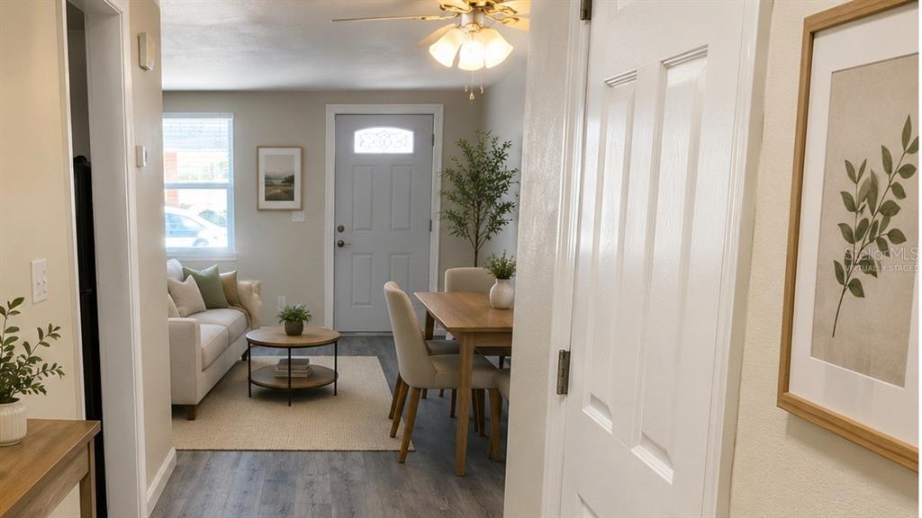 A living and dining area features light wood-look flooring, a ceiling fan, and a front door — 5000 BITNER STREET, NEW PORT RICHEY, FL