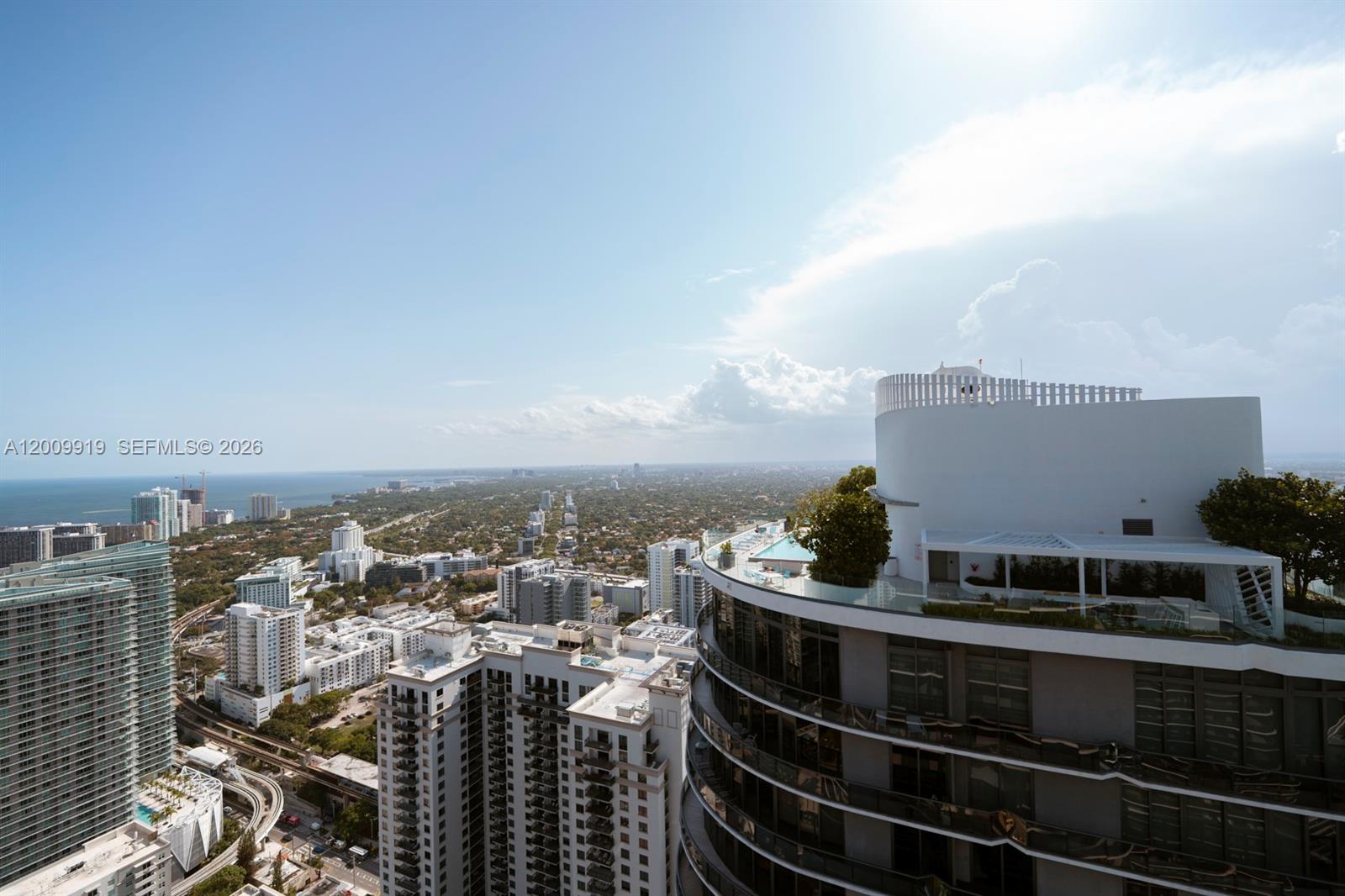 An elevated view shows a modern high-rise building with a rooftop pool and terrace — 45 SW 9th St # 4906, Miami FL 33130, MIAMI, FL