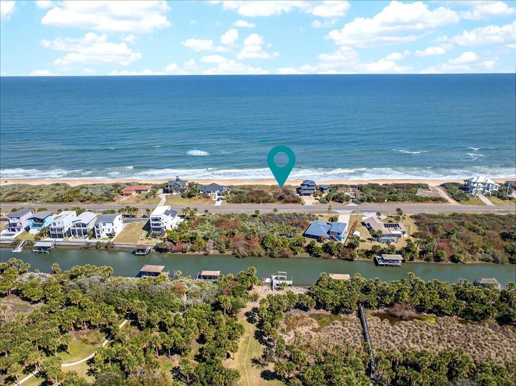 An aerial view shows a coastal property with a house located between the ocean and canal — 3527 N OCEAN SHORE BOULEVARD, PALM COAST, FL