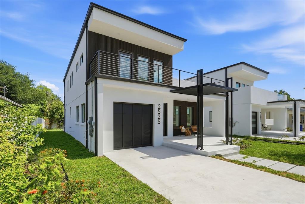 A modern two-story house with a white exterior, dark wood accents, and a front garage — 2525 18TH AVENUE N, ST PETERSBURG, FL