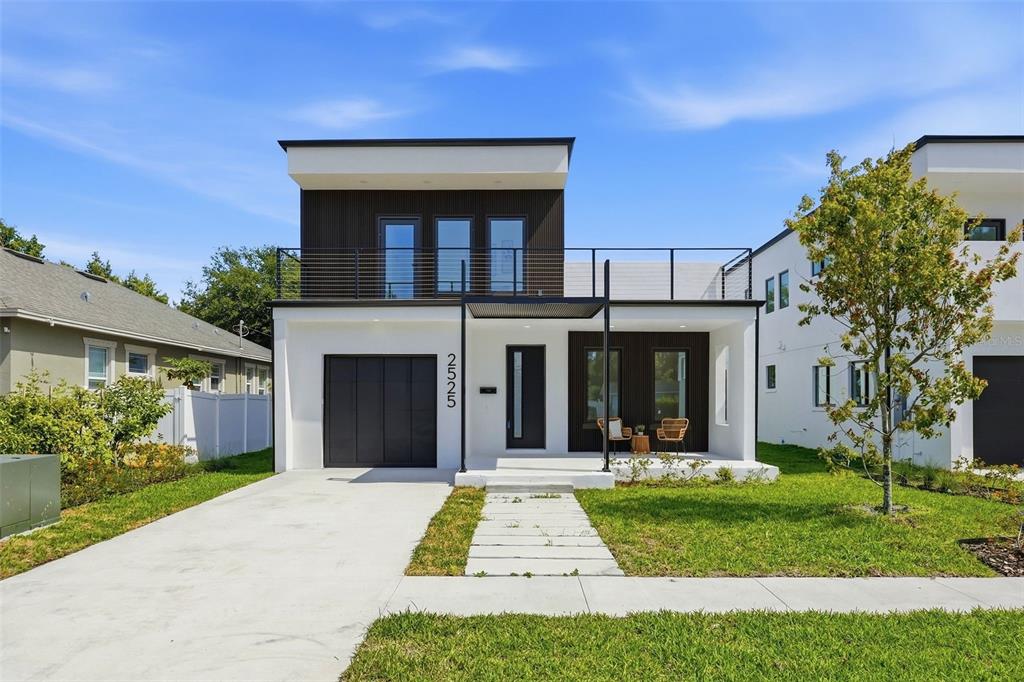 A modern two-story house with a flat roof, white stucco, and dark wood paneling — 2525 18TH AVENUE N, ST PETERSBURG, FL