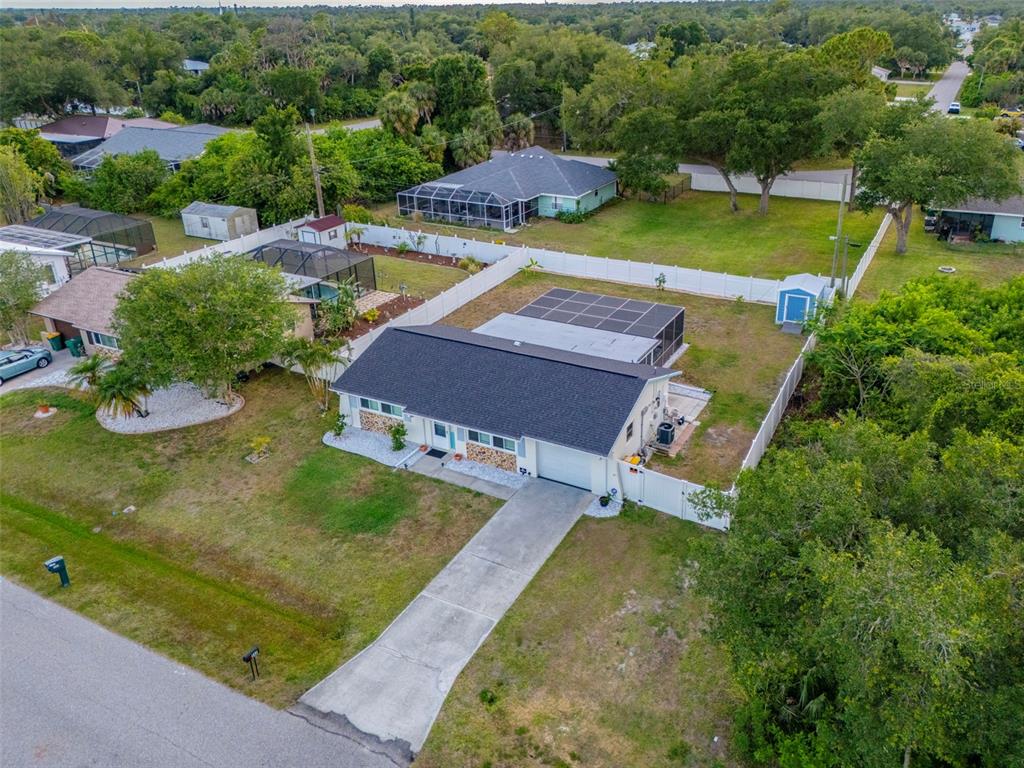 An aerial view shows a single-story house with a pool enclosure and a fenced yard — 342 AURORA STREET, PORT CHARLOTTE, FL