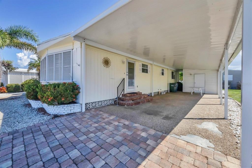 A mobile home exterior features a paved driveway, a covered carport, and a small porch — 14 S FLORA VISTA STREET, ENGLEWOOD, FL