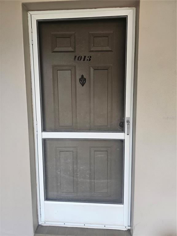A brown front door with a screen door and the number 1013 on the exterior — 5265 E BAY DRIVE UNIT 1013, CLEARWATER, FL