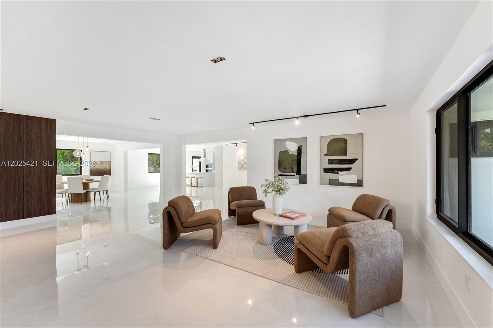 A modern living room features four brown armchairs arranged around a round stone coffee table — 10825 SW 80th Ave, Miami FL 33156, MIAMI, FL