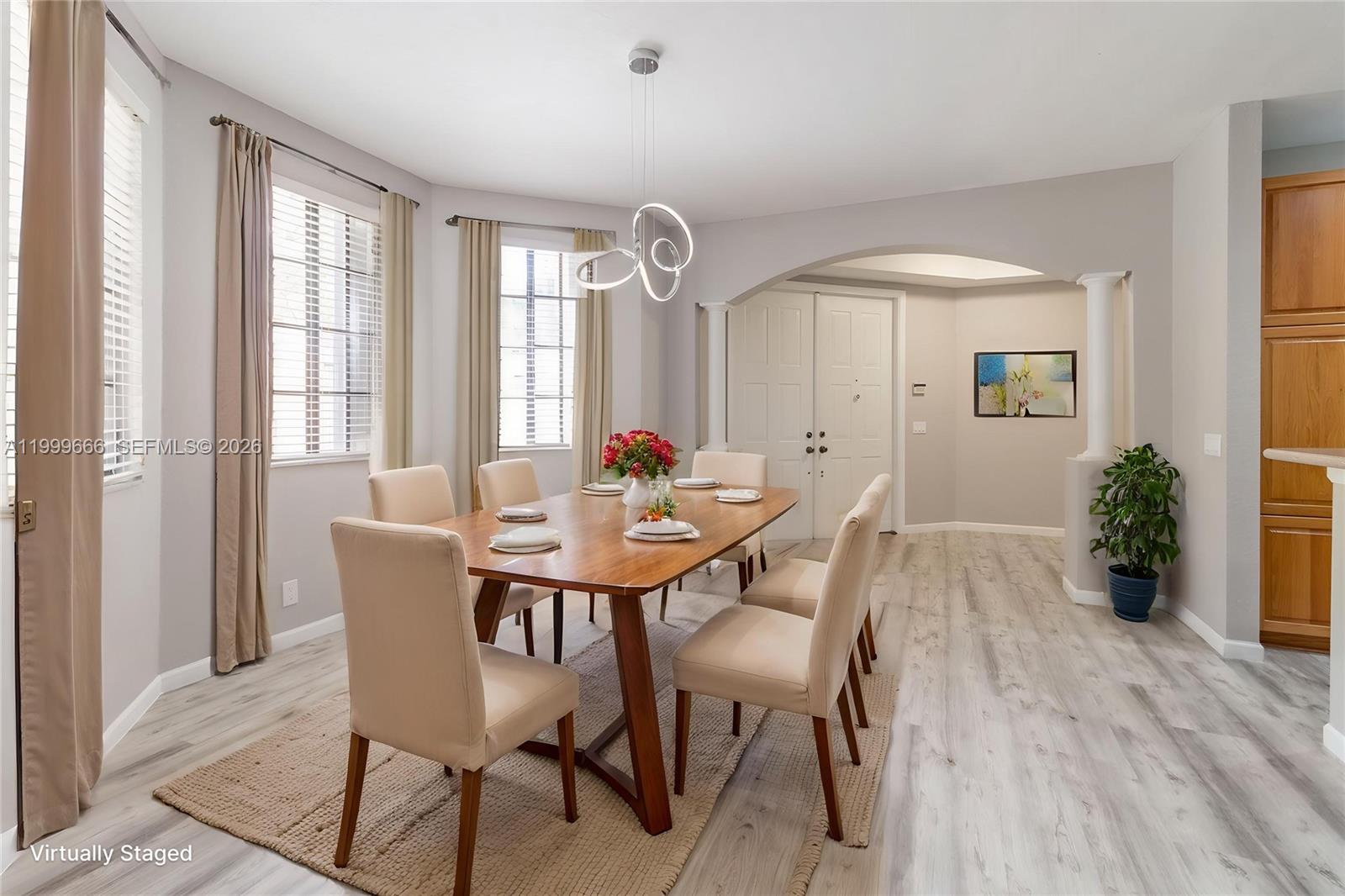 A dining room features a wooden table, six chairs, a modern light fixture, and flooring — 1611 Passion Vine Cir # 2, Weston FL 33326, WESTON, FL