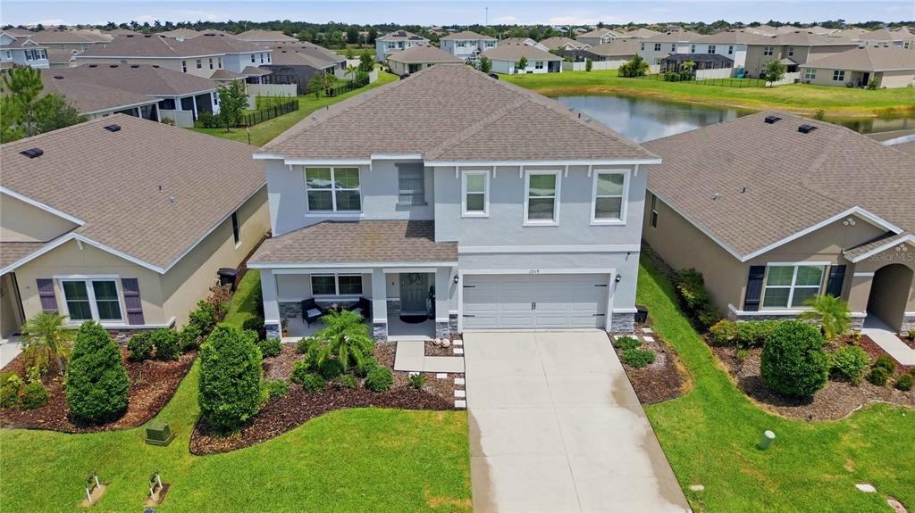 An aerial view of a two-story suburban house with a gray exterior and attached garage — 17119 HARVEST MOON WAY, BRADENTON, FL