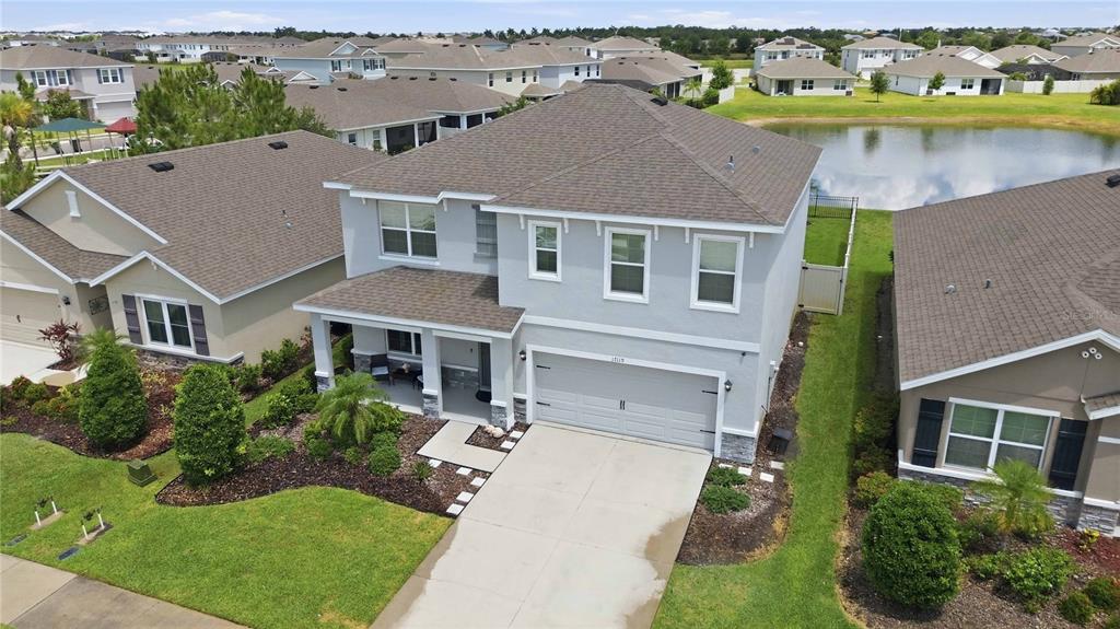 An aerial view of a two-story suburban house with a gray exterior and shingled roof — 17119 HARVEST MOON WAY, BRADENTON, FL
