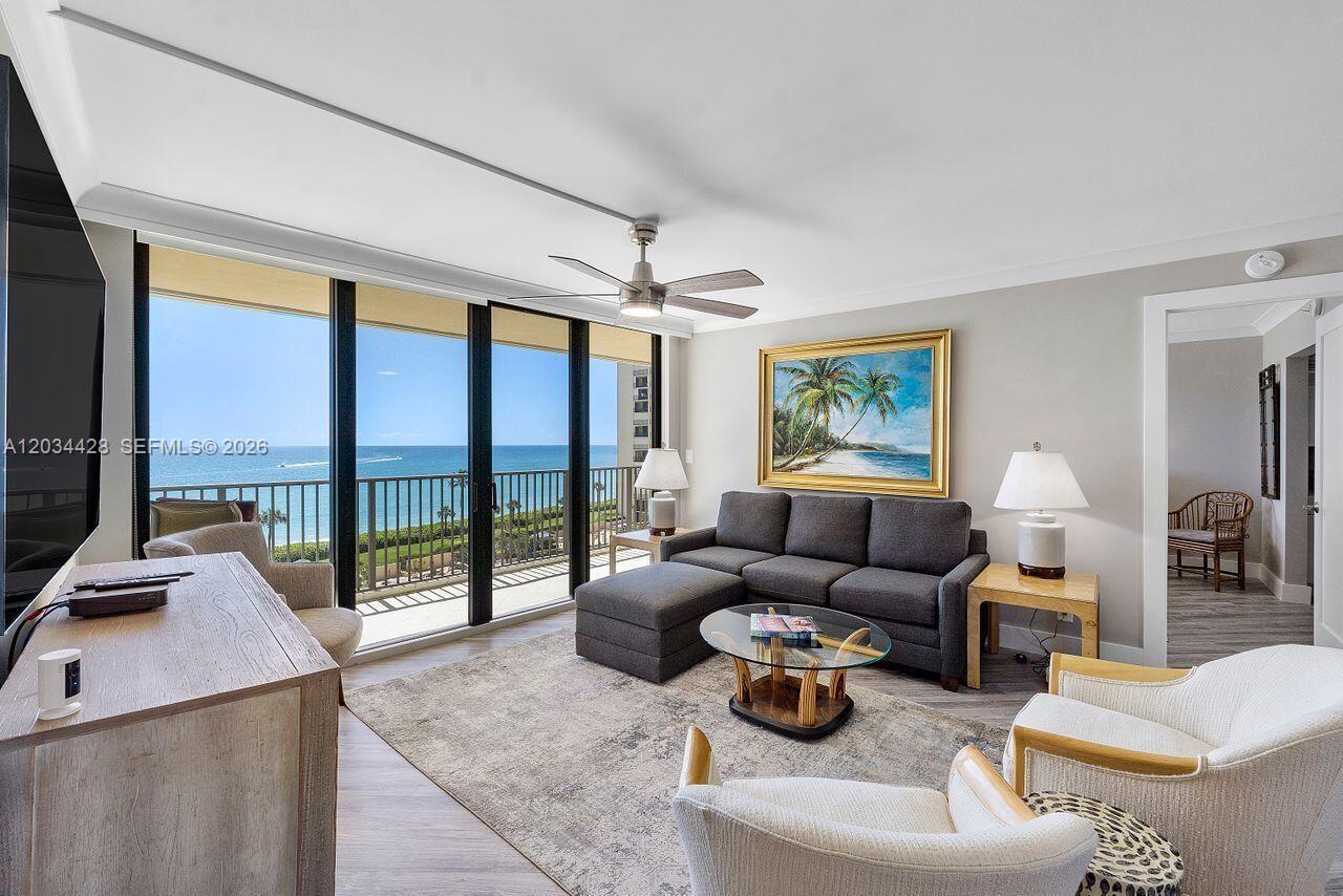 A living room features a grey sectional sofa, two armchairs, and a balcony overlooking the ocean — 200 Ocean Trail Way # 602, Jupiter FL 33477, JUPITER, FL