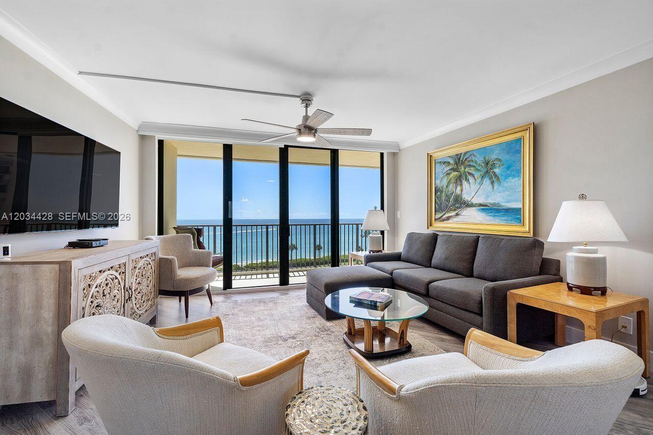 A living room features a gray sectional sofa, two armchairs, and a view of the ocean — 200 Ocean Trail Way # 602, Jupiter FL 33477, JUPITER, FL