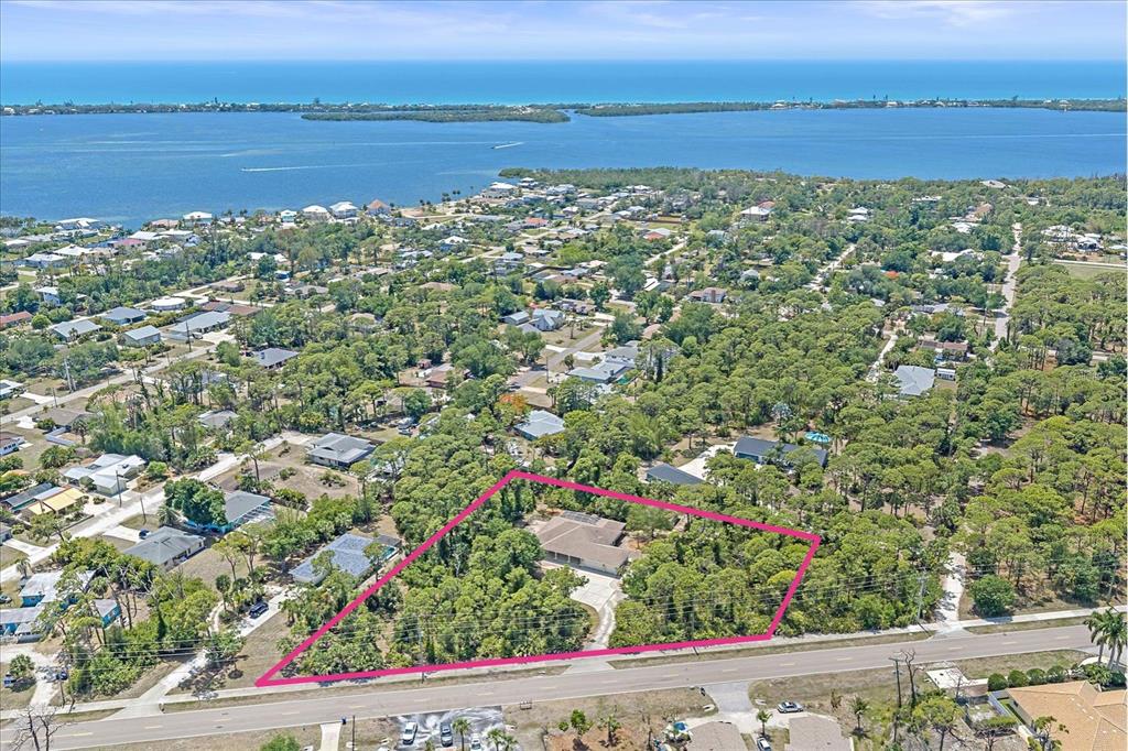 An aerial view shows a house on a large, wooded lot near the water — 630 OLD ENGLEWOOD ROAD, ENGLEWOOD, FL