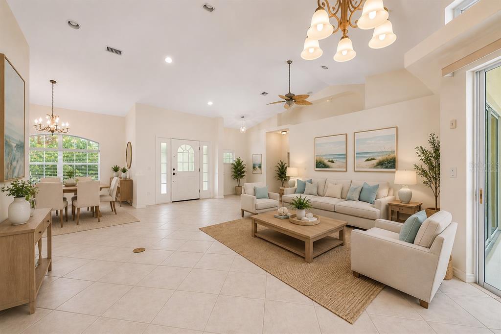 A bright, open-concept living and dining area features tile floors, vaulted ceilings, and coastal decor — 630 OLD ENGLEWOOD ROAD, ENGLEWOOD, FL