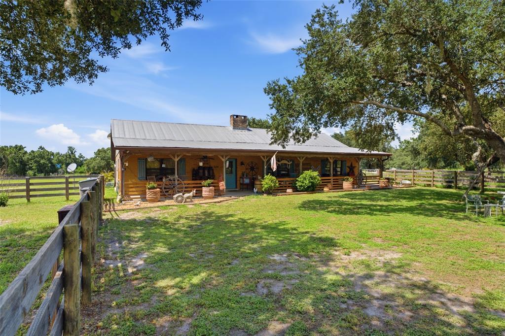 A single-story ranch-style house with a metal roof and a covered front porch — 7674 SW ENVIRONMENTAL LAB STREET, ARCADIA, FL