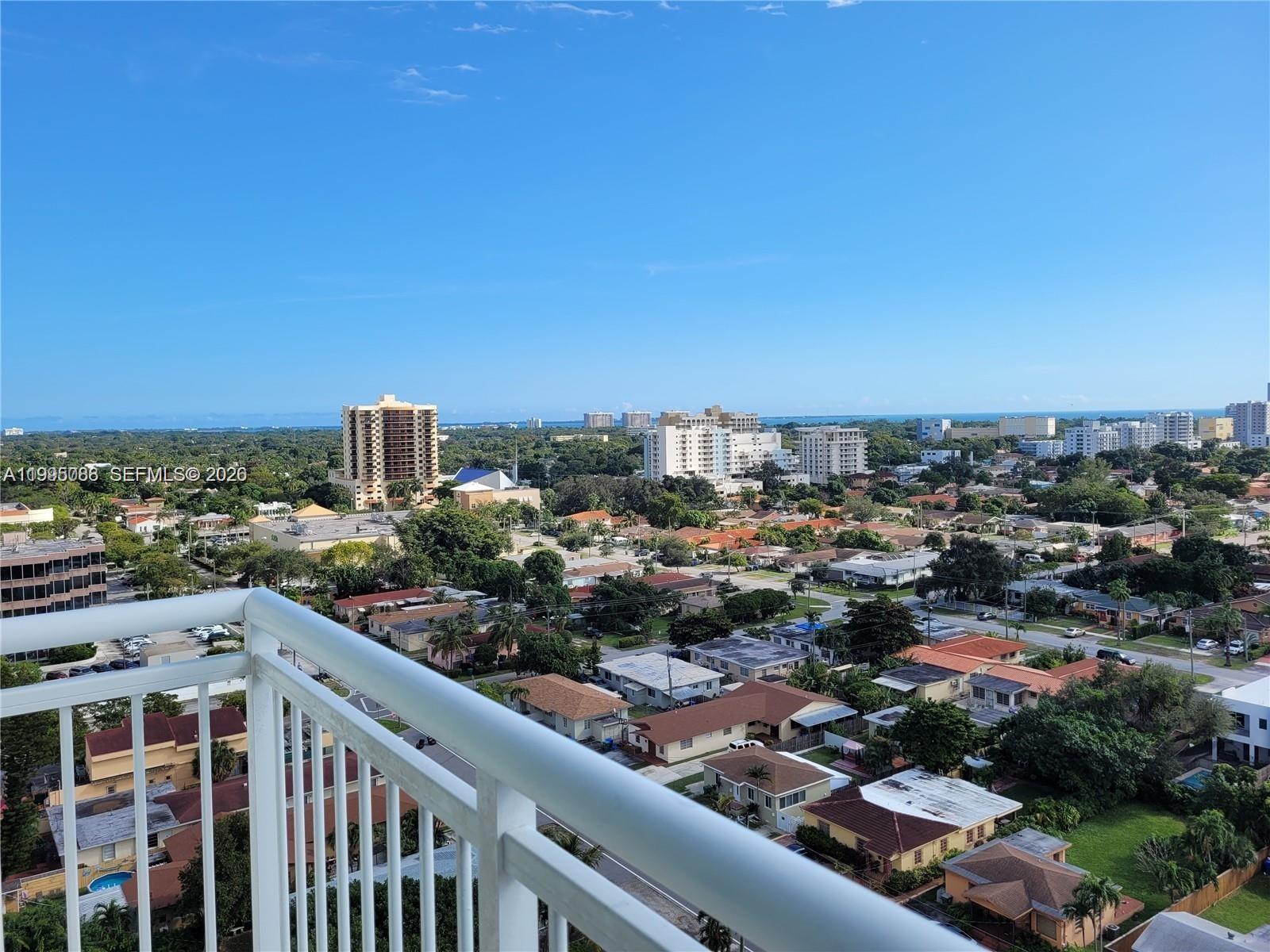 An elevated view from a balcony overlooks a residential neighborhood with distant high-rise buildings — 3000 Coral Way # 1512, Miami FL 33145, MIAMI, FL
