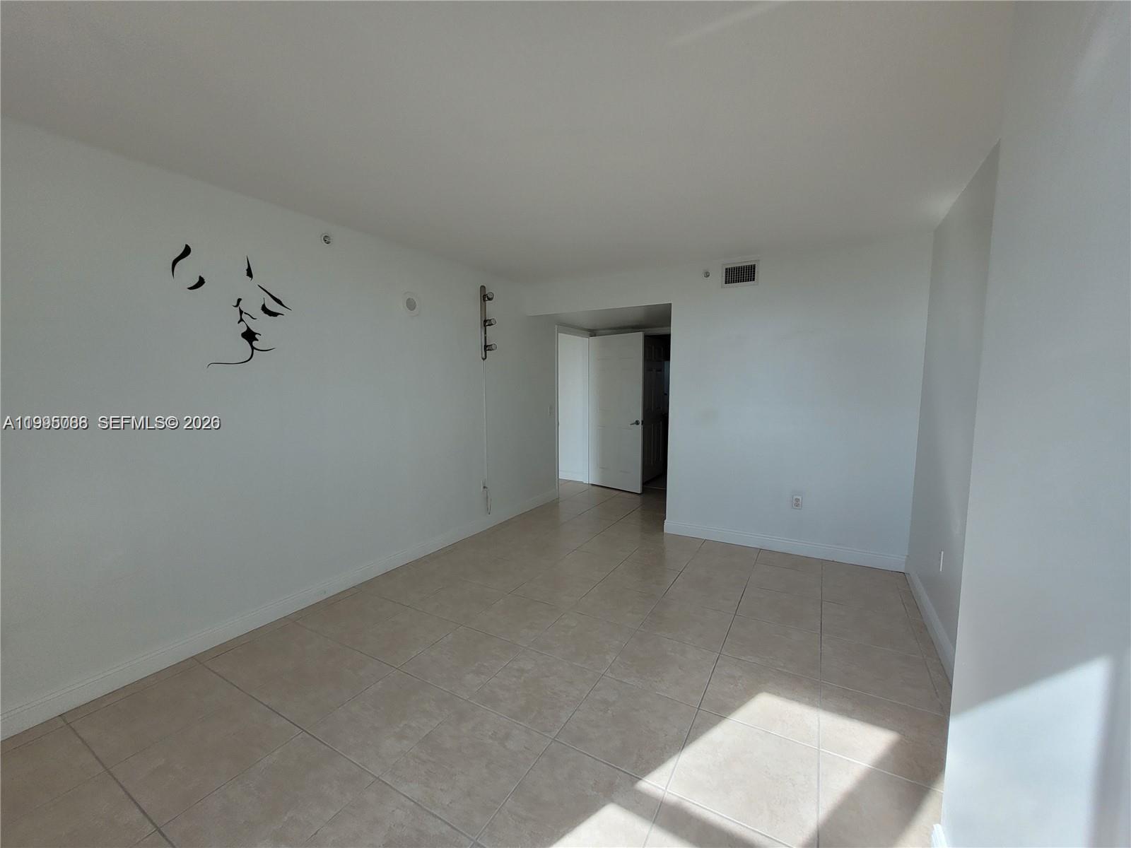 An empty room features white walls, tile flooring, and a doorway leading to another area — 3000 Coral Way # 1512, Miami FL 33145, MIAMI, FL