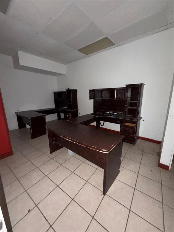An office room features two dark wood desks, white walls, and light-colored tiled flooring — 179 AVE JOSE DE DIEGO, ARECIBO, PR