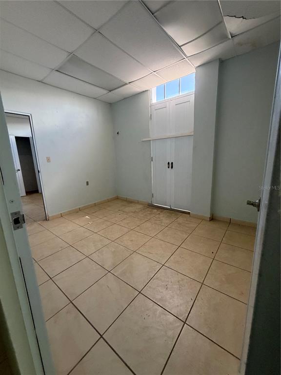 An empty room with light-colored tile flooring, a drop ceiling, and white double doors — 179 AVE JOSE DE DIEGO, ARECIBO, PR