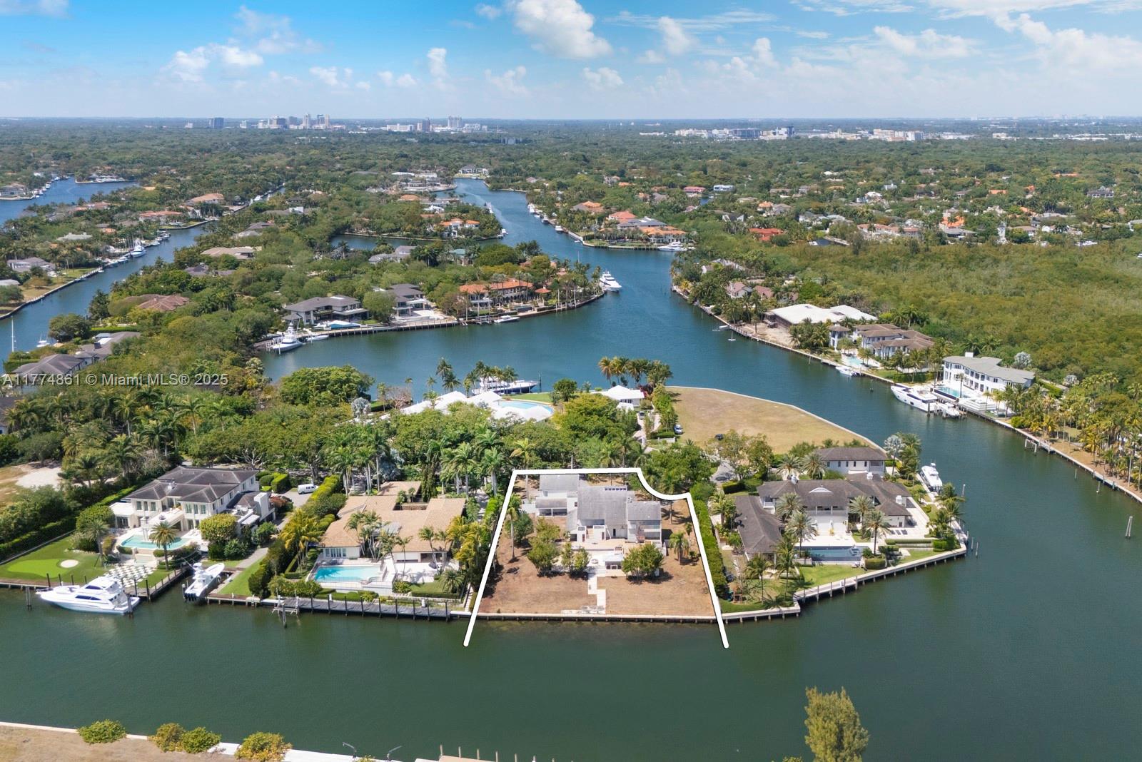 An aerial view shows a waterfront house with a large yard on a canal — 30 Leucadendra Dr, Coral Gables FL 33156, CORAL GABLES, FL