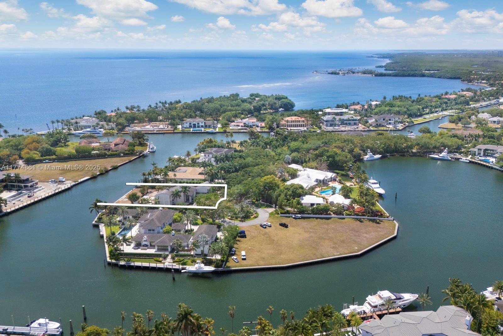 An aerial view shows a waterfront property with a large house and a vacant lot — 30 Leucadendra Dr, Coral Gables FL 33156, CORAL GABLES, FL