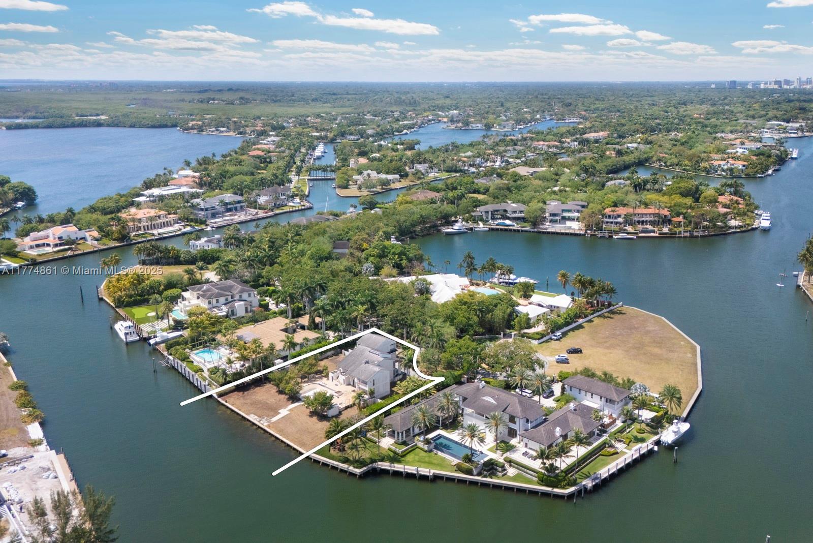 An aerial view shows a waterfront residential property highlighted by white lines on a peninsula — 30 Leucadendra Dr, Coral Gables FL 33156, CORAL GABLES, FL