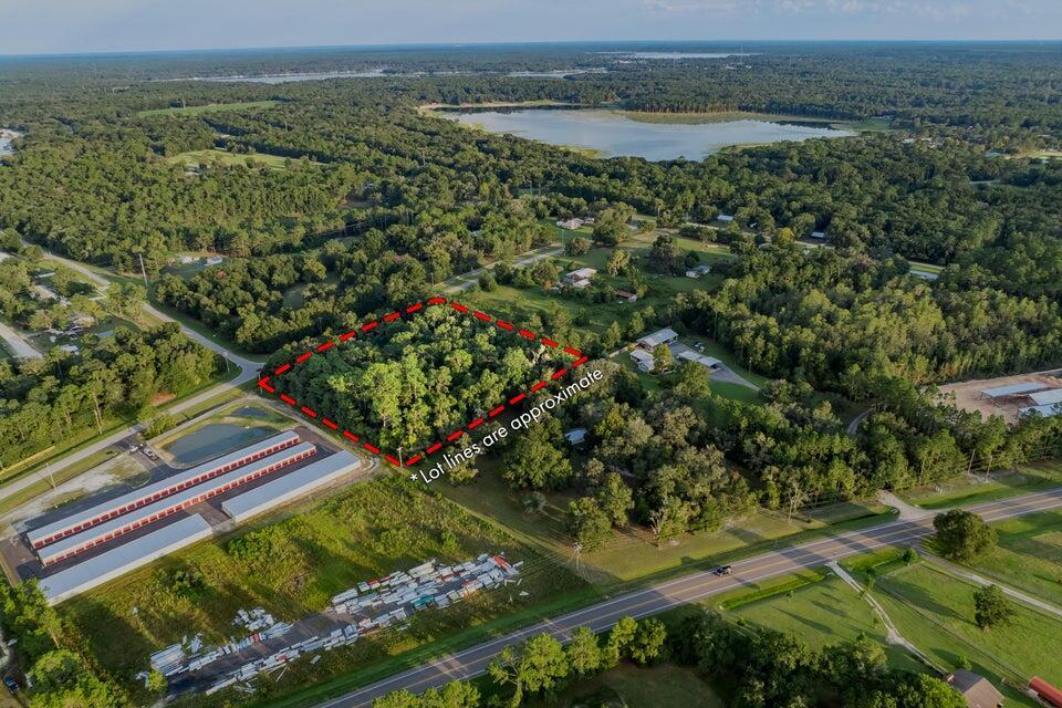 An aerial view shows a wooded rectangular lot outlined in red near a road — 0000 SE 9th Avenue, Starke FL 32091, STARKE, FL