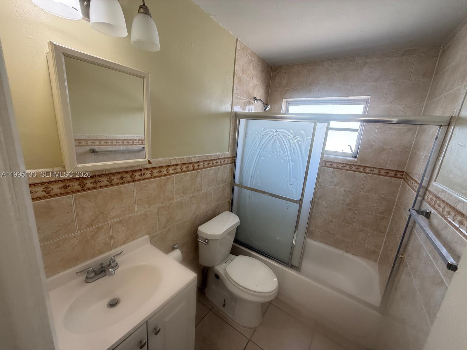 A bathroom features a vanity, a toilet, and a tiled shower-tub combination with sliding doors — 17530 NW 68th Ave # C4013, Hialeah FL 33015, HIALEAH, FL