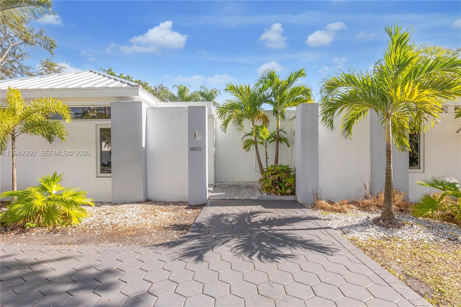 A modern white house exterior features a hexagonal paver walkway and several palm trees — 18555 SW 83rd Pl, Cutler Bay FL 33157, CUTLER BAY, FL