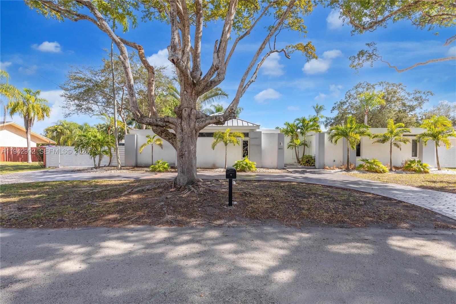 A single-story white house with a circular driveway and a large tree in the front — 18555 SW 83rd Pl, Cutler Bay FL 33157, CUTLER BAY, FL