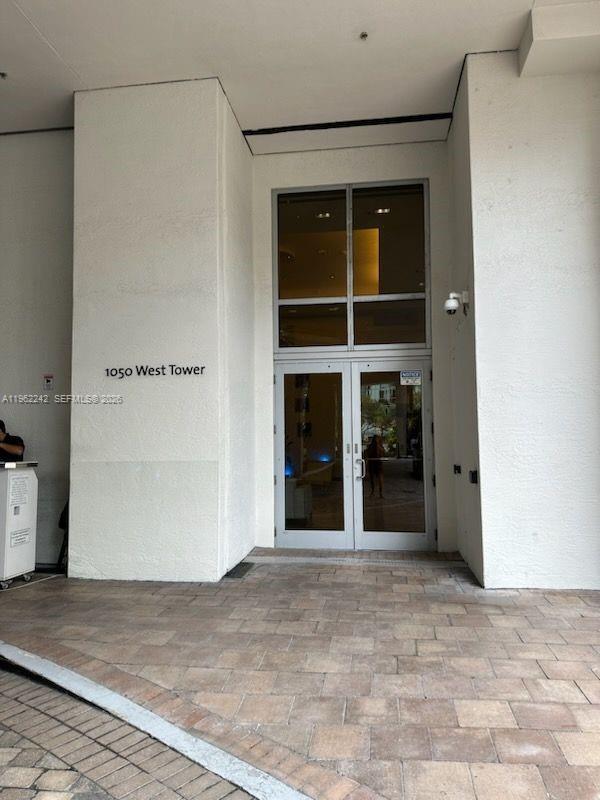 The entrance to the 1050 West Tower features glass double doors and a paved driveway — 1050 Brickell Ave # 1014, Miami FL 33131, MIAMI, FL