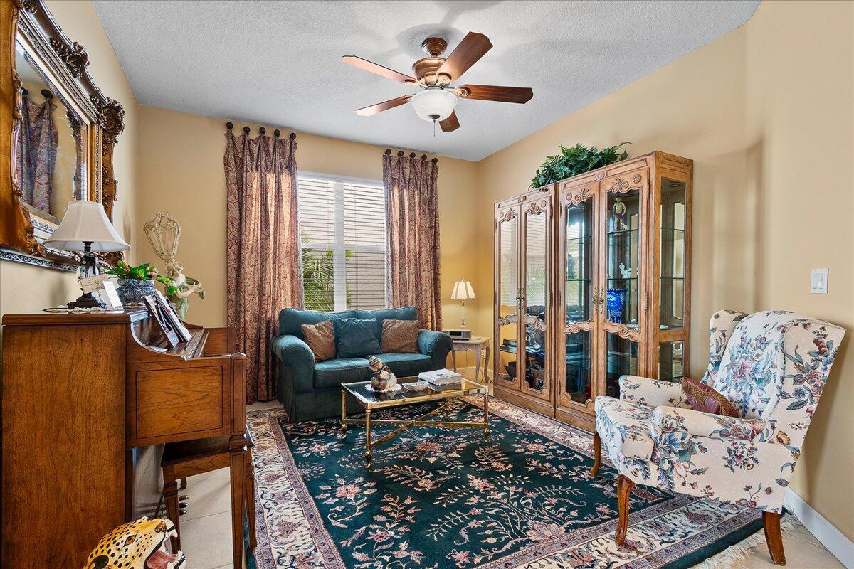 A living room features a dark floral rug, a teal sofa, and a floral armchair — 135 Hamilton Terrace, West Palm Beach FL 33414, WEST PALM BEACH, FL