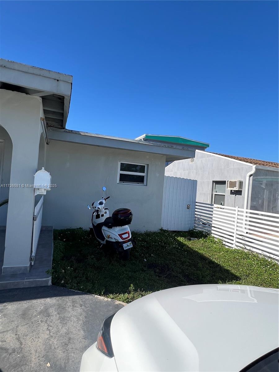 A white scooter is parked on the lawn in front of a house exterior — 720 NW 30th Ave, Miami FL 33125, MIAMI, FL